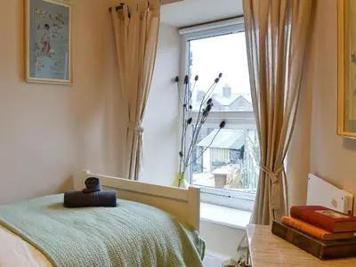 a bedroom with a bed and a window at Tŷ Ar Y Tro in Tanygrisiau