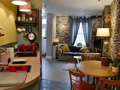 a kitchen and living room with a table and a couch at Tŷ Ar Y Tro in Tanygrisiau