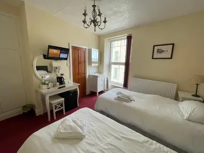 a hotel room with two beds and a mirror at Môr Wyn Guest House in Barmouth