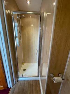 a shower with a glass door in a bathroom at Môr Wyn Guest House in Barmouth