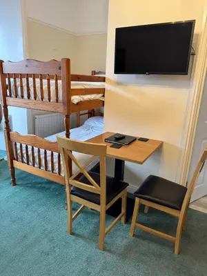 a room with a desk and a bunk bed and a television at Môr Wyn Guest House in Barmouth