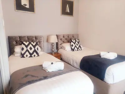 a room with three beds and a chair in it at The Black Lion Royal Hotel in Lampeter
