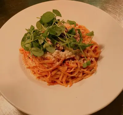 a plate of pasta with greens on top of it at The Black Lion Royal Hotel in Lampeter
