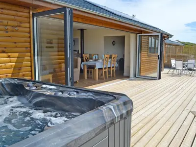 a hot tub on the deck of a house at Bluebell Lodge in Llandrindod Wells