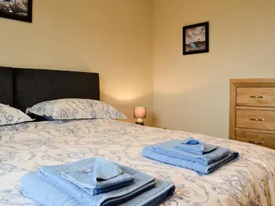 a bedroom with a bed with blue towels on it at Bluebell Lodge in Llandrindod Wells