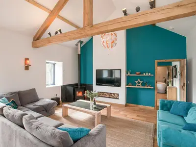 a living room with a couch and a table at The Pendre Longbarn in Pentre-briwnant