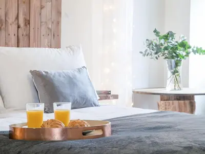 a tray of orange juice and croissants on a bed at The Pendre Longbarn in Pentre-briwnant