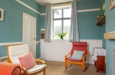 a room with two chairs and a window at Station Cottage in Bucknell
