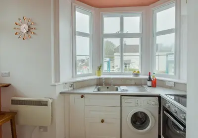a kitchen with a sink and a washing machine at Station Cottage in Bucknell