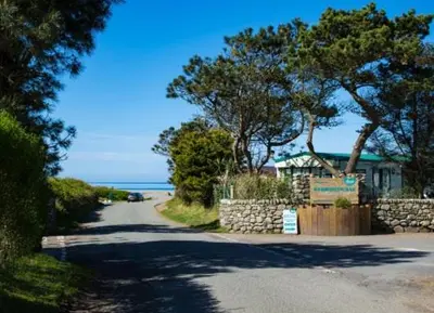 a road leading to a house on a beach at 92 Barmouth Bay Holiday Park in Llanddwywe