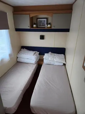 two beds in a small room on a train at 92 Barmouth Bay Holiday Park in Llanddwywe