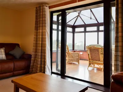 a living room with a couch and a glass door at Bryn Villa in Newbridge on Wye