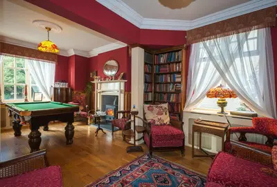 a living room with a pool table and a fireplace at Ardwyn House in Llanwrtyd Wells