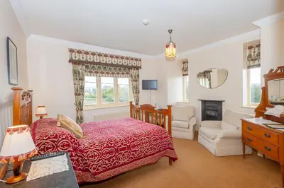 a bedroom with a bed and a chair and a table at Ardwyn House in Llanwrtyd Wells