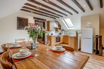 a kitchen and dining room with a wooden table at 2 Bed in Trallong oc-bow106 in Sennybridge