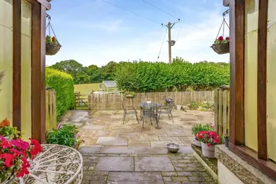 a patio with a table and chairs in a yard at 2 Bed in Trallong oc-bow106 in Sennybridge