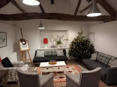 a living room with a christmas tree and a couch at Gesail Barn and Farmhouse in Machynlleth