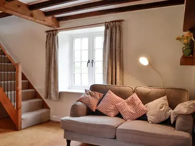 a living room with a couch and a window at Bridge End Cottage in Cregrina
