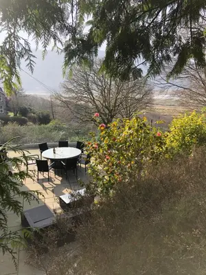 a table and chairs in a garden with flowers at Snowdonia Mawddach escape in Dolgellau