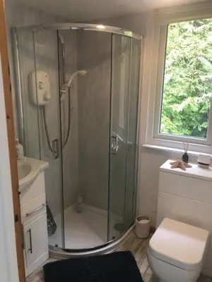 a bathroom with a shower and a toilet and a window at Snowdonia Mawddach escape in Dolgellau