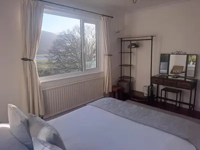 a bedroom with a bed and a large window at Snowdonia Mawddach escape in Dolgellau