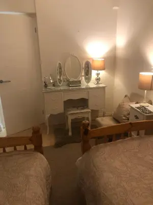 a bedroom with two beds and a vanity with a mirror at Snowdonia Mawddach escape in Dolgellau