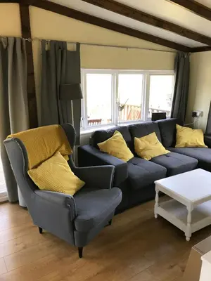 a living room with a blue couch and yellow pillows at Sherdale lodge in Builth Wells
