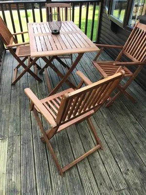 two chairs and a wooden table on a deck at Sherdale lodge in Builth Wells