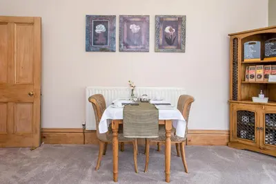 a dining room table with a white table cloth at LLys Aeron 
