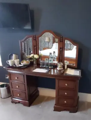 a wooden desk with two mirrors on a blue wall at LLys Aeron 