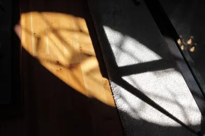 a shadow of a door with the sun shining through at Glanhenwye Courtyard Cottages in Glasbury