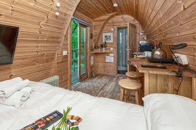 a bedroom with a bed in a wooden cabin at Nyth Y Goedwig in Dolgellau