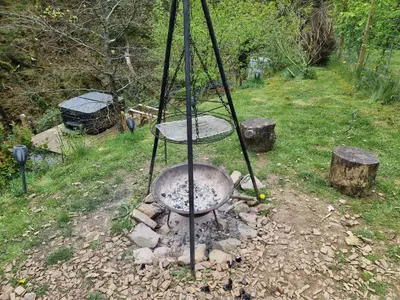 a metal stove in a field with rocks at Nyth Y Goedwig in Dolgellau