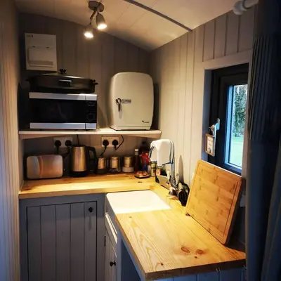 a small kitchen with a sink and a microwave at Pen-Rhos luxury glamping 