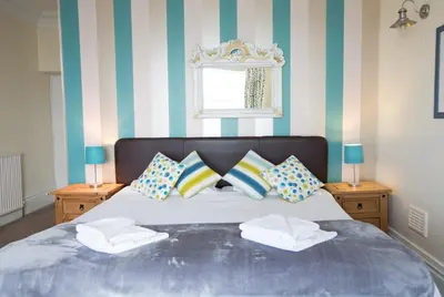 a bedroom with a bed with pillows and a window at Min y Mor Hotel in Barmouth
