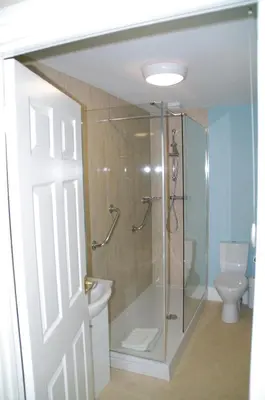 a bathroom with a shower and a toilet at Min y Mor Hotel in Barmouth