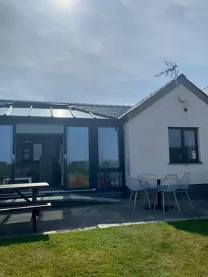 a patio with a table and chairs and a building at The Milking Parlour in Aberystwyth