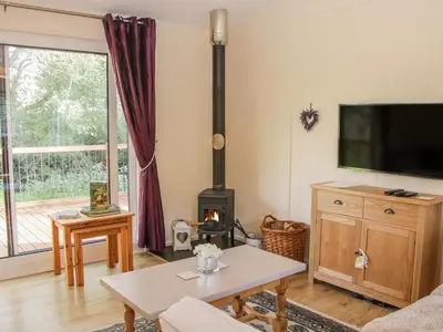 a living room with a tv and a fireplace at Alder River Lodge Clun Valley Luxury Hot Tub Break in Craven Arms