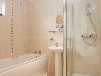 a bathroom with a bath tub and a sink and a shower at Alder River Lodge Clun Valley Luxury Hot Tub Break in Craven Arms