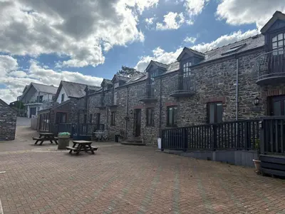 a row of buildings with benches in front of them at The Stores in Aberystwyth