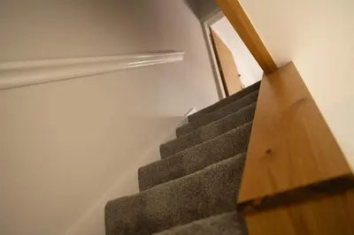 a set of stairs with a wooden hand rail at Rose Cottage in Shrewsbury