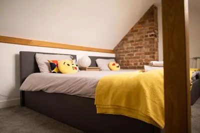 a bedroom with a bed with stuffed animals on it at Rose Cottage in Shrewsbury
