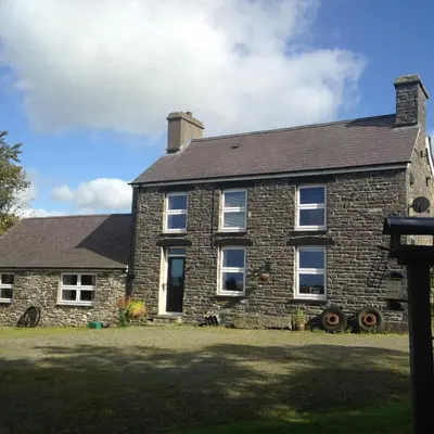 an old brick house with a black roof at Rhydgaled in Llanon