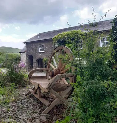 a wooden wheel sitting in front of a building at The Mews, Talley in Llandeilo