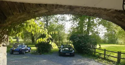 two old cars parked under a stone bridge at The Mews, Talley in Llandeilo