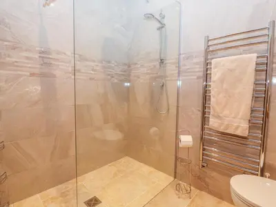 a bathroom with a glass shower with a toilet at The Tractor Shed in Oswestry