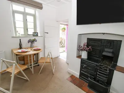 a kitchen with a table and a black stove at Rectory Cottage in Oswestry
