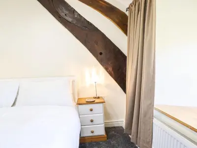 a bedroom with a bed and a window at Cwm Yr Afon Mawr in Llanbedr