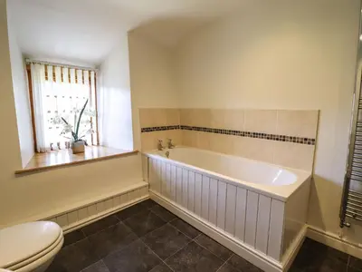 a bathroom with a tub and a toilet at Cwm Yr Afon Mawr in Llanbedr