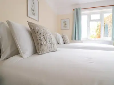 a white bed with white pillows and a window at Bower View in Hereford